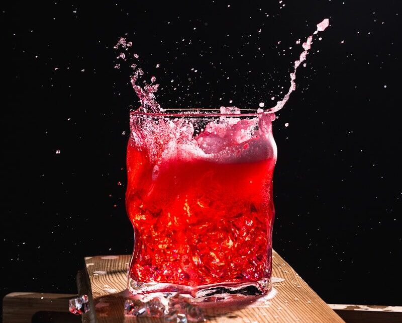 red liquid in clear drinking glass