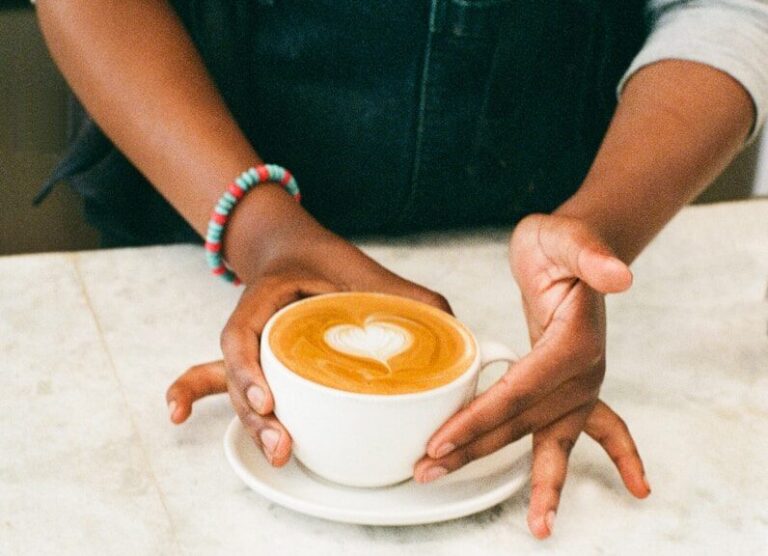 a woman is holding a cup of coffee